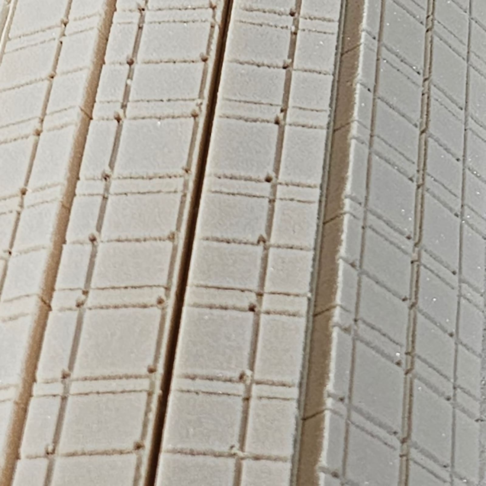 Close-up of a rigid PVC foam sheet with grooves and channels.