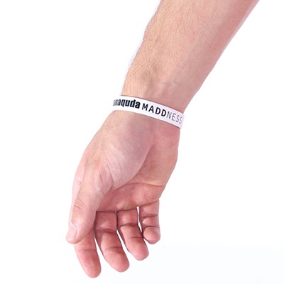 Hand mit weißem Armband, Aufschrift 'MADNESS'.