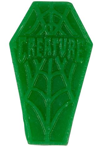 Grünes Objekt in Form eines Sargs mit Spinnennetzmuster und dem Wort 'CREATURE'.