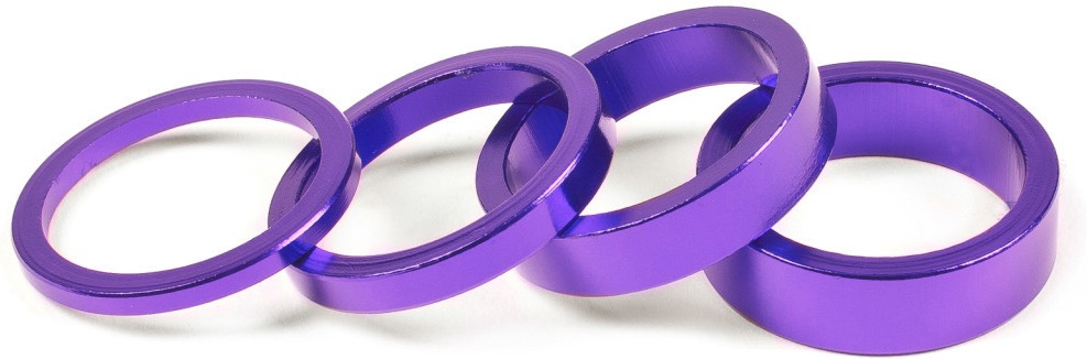 Vier lila Aluminiumringe liegen auf einer weißen Oberfläche.