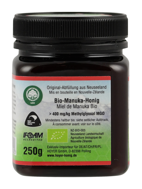 Produktfoto: Ein Glas Bio-Manuka-Honig der Marke TranzAlpine ist abgebildet. Das Etikett zeigt ein Bergmotiv und die Aufschrift 'Bio-Organic Manuka Honey MGO 400+ aus Neuseeland'. Der Honig ist in einem dunklen Glas mit schwarzem Deckel verpackt.
