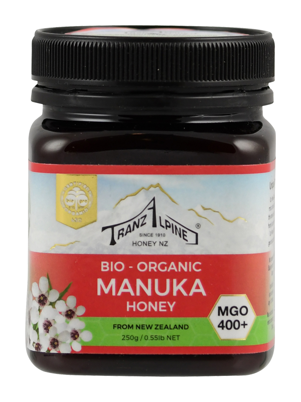 Produktfoto: Ein Glas Bio-Manuka-Honig der Marke TranzAlpine ist abgebildet. Das Etikett zeigt ein Bergmotiv und die Aufschrift 'Bio-Organic Manuka Honey MGO 400+ aus Neuseeland'. Der Honig ist in einem dunklen Glas mit schwarzem Deckel verpackt.