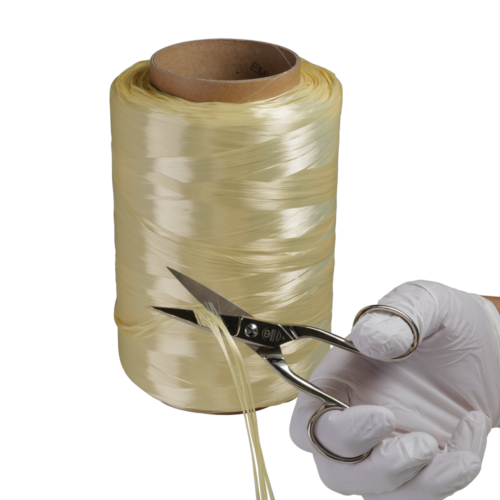 A large spool of yellow ribbon being cut with scissors held by a gloved hand.