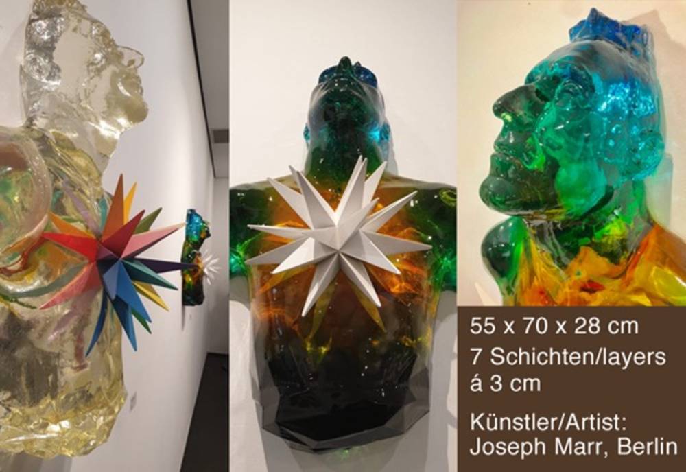Drei Skulpturen von Joseph Marr mit bunten, sternförmigen Elementen auf Brusthöhe. Maße: 55x70x28 cm, 7 Schichten à 3 cm.