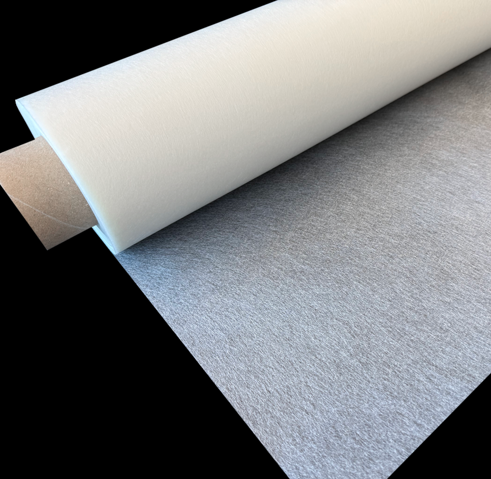 A large roll of white and gray material, partially unrolled, on a black background.