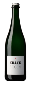 Produktfoto: Grüne Weinflasche mit weißem Etikett, Aufschrift 'KRACK SECCO'. Silberner Kronkorken.