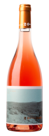 Produktfoto: Eine Roséweinflasche mit orangefarbenem Verschluss und Etikett mit Landschaftsbild.