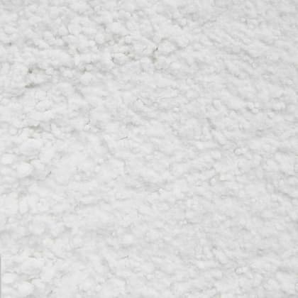 Nahaufnahme einer weißen, körnigen Substanz mit unregelmäßiger Textur.