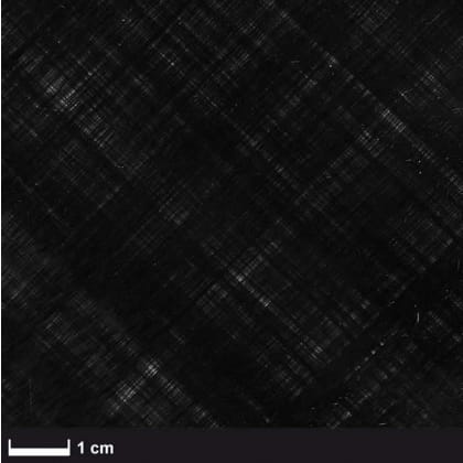 Das Bild zeigt eine Nahaufnahme eines schwarzen, gewebten Materials mit einem Maßstab von 1 cm.
