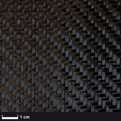 Nahaufnahme eines gewebten Musters aus dunklen Fasern mit einem Maßstab von 1 cm.