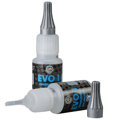 Zwei kleine Flaschen mit silbernen Kappen, eine stehend, eine liegend. Aufschrift “EVO 1“ und “niedrigviskos“ sichtbar.