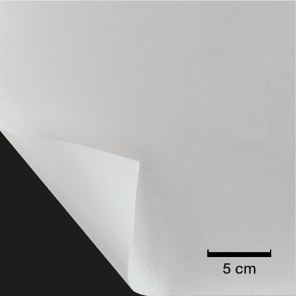 Ein weißes Vlies ist an einer Ecke umgeknickt. Der Hintergrund ist schwarz. Ein Maßstab von 5 cm ist sichtbar.
