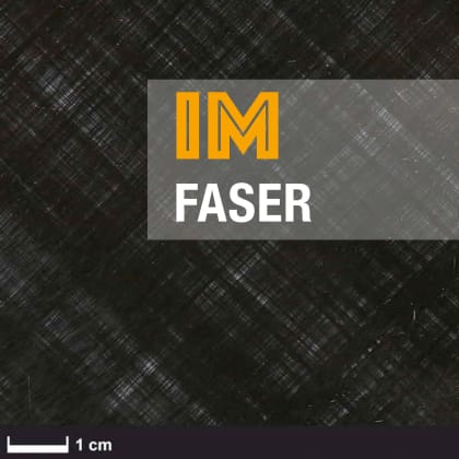 Eine Rolle schwarzes Material mit weißem Rand, teilweise abgewickelt auf einer weißen Oberfläche. Das Material hat eine strukturierte Oberfläche.